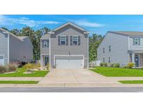 Charming gray two-story home featuring a two-car garage, landscaped front yard, and welcoming curb appeal at 396 Emery Oak Dr., Murrells Inlet, SC 29576