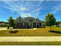 Charming home boasts a manicured lawn, brick accents, and dormer windows, creating an inviting curb appeal at 4008 Tupelo Ct., Conway, SC 29526