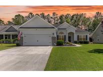 Charming single-story home featuring a well-manicured lawn and an attached two-car garage at 404 Windermere Lake Circle, Conway, SC 29526
