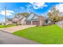 Charming light blue home with a two-car garage and a well-manicured lawn under a bright blue sky at 460 Boundary Ave. # A & B, Murrells Inlet, SC 29576