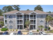 Attractive condo complex featuring a charming grey brick facade and multiple private balconies at 4771 Wild Iris Dr. # 103, Myrtle Beach, SC 29577