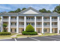 Attractive condo building featuring classic white pillars, multiple balconies and a landscaped walkway entrance at 5000 Windsor Green Way # 102, Myrtle Beach, SC 29579