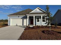 Charming single-story home featuring a two-car garage, red front door, and manicured landscaping at 519 Blissful Ln., Little River, SC 29566