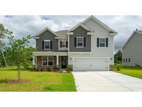 Charming two-story home with stone accents, a two-car garage, and well-manicured landscaping at 7039 Shooting Star Way, Myrtle Beach, SC 29579
