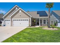Inviting home featuring a well-manicured lawn, attached two-car garage and solar panels at 757 Cherry Blossom Dr., Murrells Inlet, SC 29576