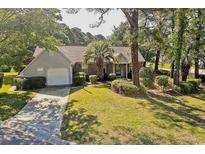 Charming single-story home with a manicured lawn, mature trees, and an attached garage at 802 Mockingbird Ct., Murrells Inlet, SC 29576