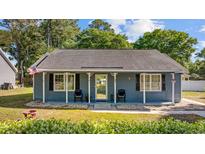 Charming single-story home featuring a covered front porch, blue siding, and well-manicured landscaping at 844 Wachesaw Rd., Murrells Inlet, SC 29576