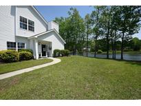 Charming home featuring a well-manicured front yard, welcoming walkway, and lovely landscaping with views of the lake at 104-4 Gully Branch Ln. # 4, Myrtle Beach, SC 29572