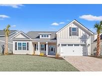 Charming single-story home featuring a manicured lawn, brick driveway, and a two-car garage at 1127 Crooked Hook Rd., North Myrtle Beach, SC 29582