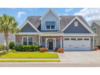 Charming two-story home featuring stone accents, gray siding, well-manicured lawn, and an attached two-car garage at 1136 Doubloon Dr., North Myrtle Beach, SC 29582