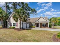 Charming single-story home with a two-car garage, well-maintained lawn, and beautiful landscaping at 1800 Wood Stork Dr., Conway, SC 29526