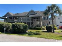 Charming condo with palm trees, well-kept landscaping, and inviting walkways to upper-level entrances at 1870 Auburn Ln. # 21 E, Surfside Beach, SC 29575