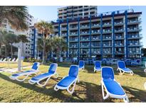 Relaxing resort featuring multiple floors, lawn, palm trees and many lounge chairs at 201 77Th Ave. N # 828, Myrtle Beach, SC 29572