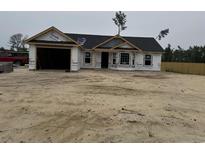 New construction home featuring a garage and windows, covered in Tyvek house wrap at 2186 Mineral Springs Rd., Conway, SC 29527