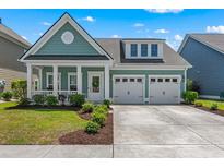 Charming single-Gathering home features a covered front porch, two-car garage, and manicured landscaping at 2464 Rock Dove Rd., Myrtle Beach, SC 29577