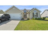 Charming single-story home featuring a well-manicured lawn and attached two-car garage at 313 Palladium Dr., Surfside Beach, SC 29575