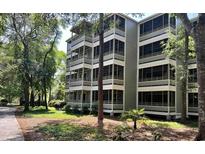 Three-story building with screened balconies and lush green surroundings at 415 Ocean Creek Dr. # 2149, Myrtle Beach, SC 29572