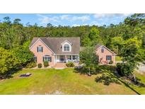 Charming two-story brick home with a welcoming front porch and lush green lawn at 4524 Ramsey Ford Rd., Tabor City, NC 28463