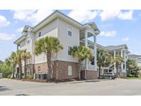 Exterior view of the condo featuring palm trees and manicured landscaping at 4803 Bovardia Pl. # 104, Myrtle Beach, SC 29577