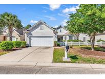 Charming single-story home featuring manicured lawn, two car garage, and inviting curb appeal on a sunny day at 4814 Greenhaven Dr., North Myrtle Beach, SC 29582