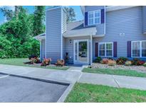 Charming two-story townhome with gray siding, colorful flower beds, and an inviting front entrance at 503 20Th Ave. N # 15-A, North Myrtle Beach, SC 29582