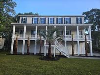 Stunning two-story home with a spacious porch, palm trees, and a well-maintained lawn at 507 Hillside Dr. N, North Myrtle Beach, SC 29582
