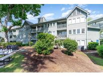 Inviting light blue multi-story building with balconies, landscaping and a swing at 5905 S Kings Highway # 6302, Myrtle Beach, SC 29575