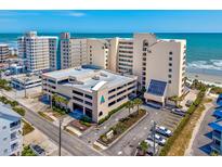 Beautiful coastal condo building features a parking garage, manicured landscaping, and ocean views at 6100 N Ocean Blvd. # 702, North Myrtle Beach, SC 29582