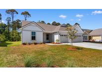 Charming one-story home with a well-manicured lawn and a three-car garage at 1421 Crested Iris Way, North Myrtle Beach, SC 29582