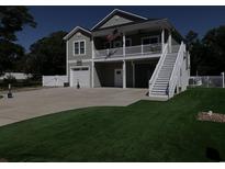 Charming two-story home with a garage, beautiful landscaping, and a welcoming second-story porch at 928 Strand Ave. Strand Ave., North Myrtle Beach, SC 29582