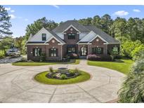 Beautiful brick two-story home featuring a circular driveway, manicured lawn, and boat parking at 9449 Freewoods Rd., Myrtle Beach, SC 29588