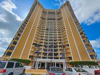 A striking view of a tall, modern condo building with a grand entrance and manicured landscaping at 9650 Shore Dr. # 2007, Myrtle Beach, SC 29572