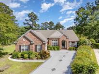 Beautiful single-story brick home with well-manicured landscaping and a spacious concrete driveway at 1004 Addington Ct., Murrells Inlet, SC 29576