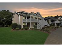 Inviting two-story condo with a neatly landscaped lawn and charming white stairs leading to the upper level at 1041 True Blue Dr. # 37A, Pawleys Island, SC 29585