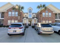 Inviting brick building exterior featuring palm trees, well-manicured grounds, and convenient parking at 119 Brentwood Dr. # D, Murrells Inlet, SC 29576