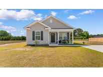 Charming single-story home with gray siding, black shutters, and a cozy front porch at 1396 Highway 129, Galivants Ferry, SC 29544