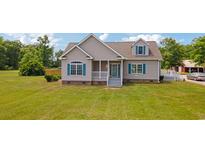 Charming single-Gathering home with a well-manicured lawn, gray siding, a covered front porch, and turquoise shutters at 151 Saddle Dr., Loris, SC 29569