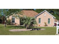 Charming, single story brick home with a manicured lawn and healthy palm tree in the front yard at 1717 Perdiz Covey Ct., Myrtle Beach, SC 29588