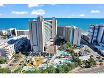 Expansive aerial view of an oceanfront resort featuring pools, waterslides, and modern architecture against a blue sky at 205 74Th Ave. N # 1104, Myrtle Beach, SC 29572