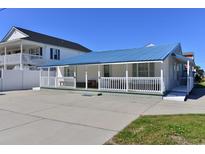 Charming single-story home featuring a blue metal roof, a welcoming front porch, and ample parking space at 219 27Th Ave. N, North Myrtle Beach, SC 29582
