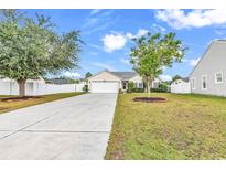Charming single-story home featuring a well-manicured lawn, attached garage, and a lengthy driveway at 4008 Scarlet Oak Ct., Myrtle Beach, SC 29579
