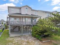 Charming raised beach home with a spacious wooden deck and covered parking with outdoor seating at 48 Sw Wilmington St., Ocean Isle Beach, NC 28469