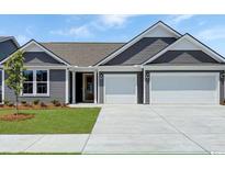 Charming one-story home featuring gray siding, a well-manicured lawn, and a spacious three-car garage at 531 Oak Landing Dr., Myrtle Beach, SC 29588