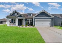 Charming single-Gathering home showcasing a well-maintained lawn and a two-car garage with a covered porch at 567 Hickman St., Myrtle Beach, SC 29575