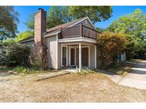 Charming two-story home featuring a brick chimney, balcony, and inviting front entrance at 607 A 28Th Ave. S, North Myrtle Beach, SC 29582