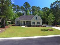 Charming home with a well-manicured lawn, mature trees, and a welcoming front porch at 625 Whispering Pines Ct., Murrells Inlet, SC 29576
