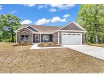 Charming single-story home features a stone facade, attached two-car garage, and well-manicured lawn at 718 Highway 348, Loris, SC 29569