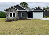 Charming single-story home featuring stone accents and a two-car garage at 722 Highway 348, Loris, SC 29569