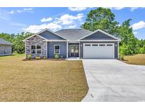 Charming single-story home with stone accents, manicured lawn, and attached two-car garage at 722 Highway 348, Loris, SC 29569