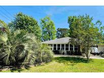 Charming home featuring a well-manicured lawn and lush tropical landscaping, offering great curb appeal at 801 Talbot Circle, Myrtle Beach, SC 29577